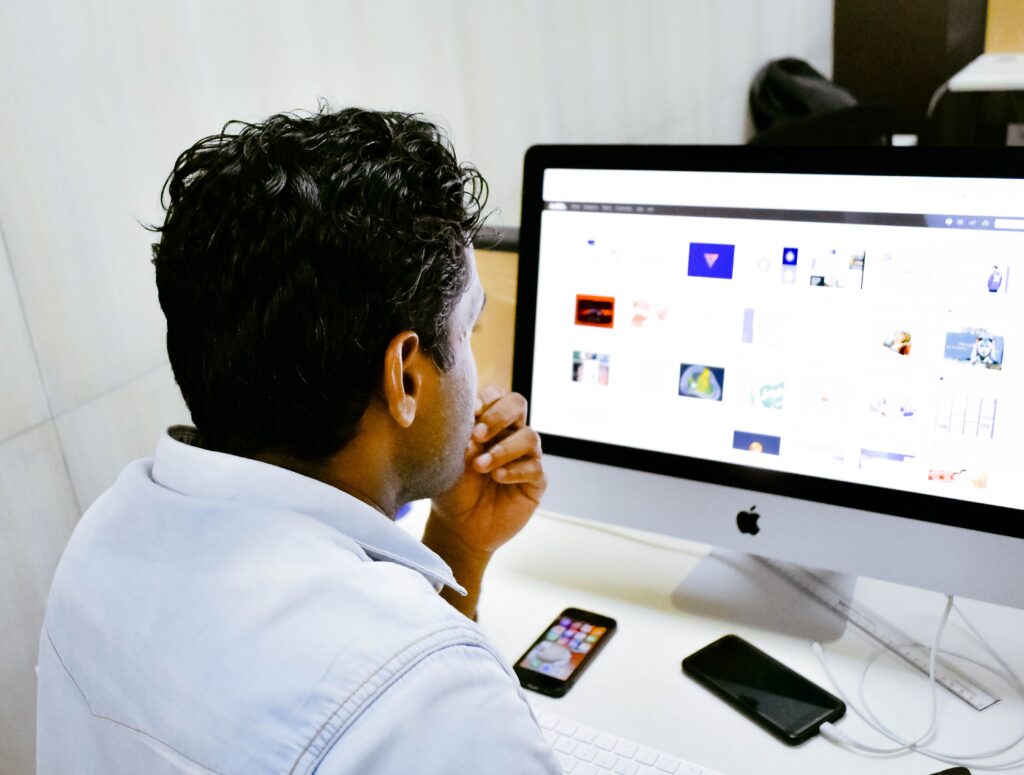 una persona mirando a la pantalla del ordenador en un escritorio de oficina